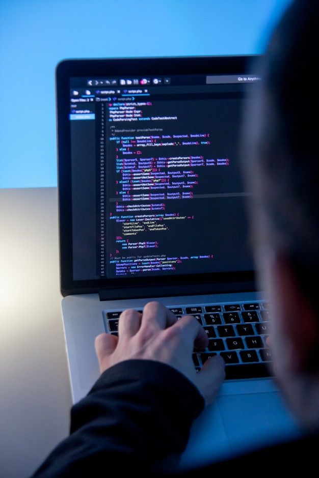 Programmer_working_on_laptop_computer_in_office_studio___Premium_Photo.jpg
